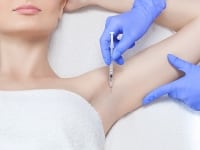 Excess-Sweat Woman getting Botox injection in the arm pit to treat excessive sweating