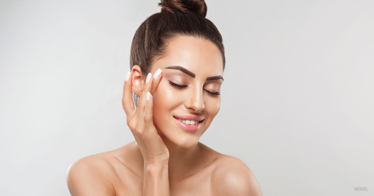 A woman smiling with glowing skin. (Model)