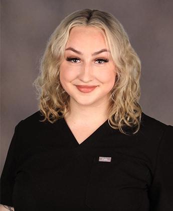 Master Esthetician Keely Gootkin | RejuvenationMD Headshot of blond woman wearing black scrubs