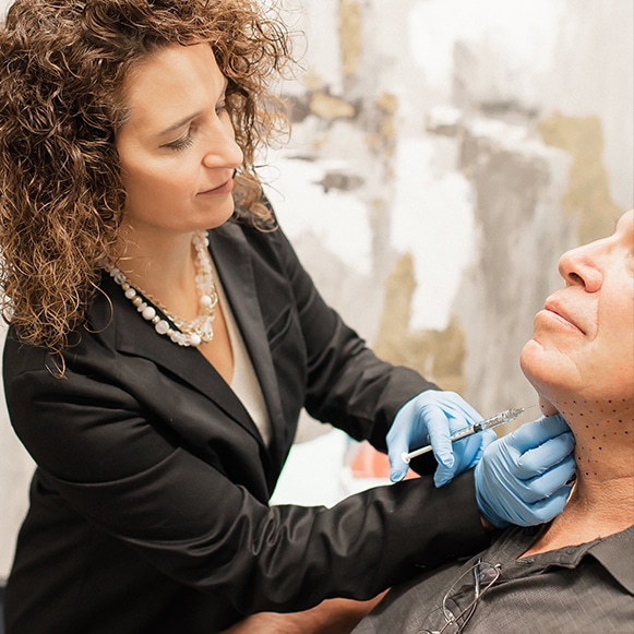 Woman injecting under the chin to kill fat with Kybella