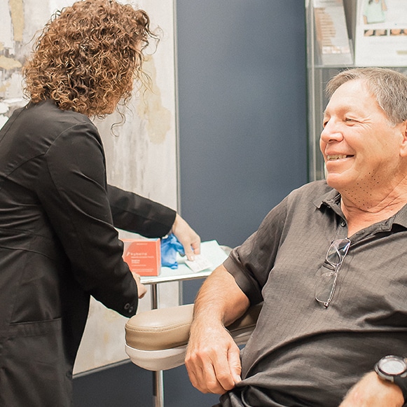 man sitting in chair with doctor preparing for Kybella treatment