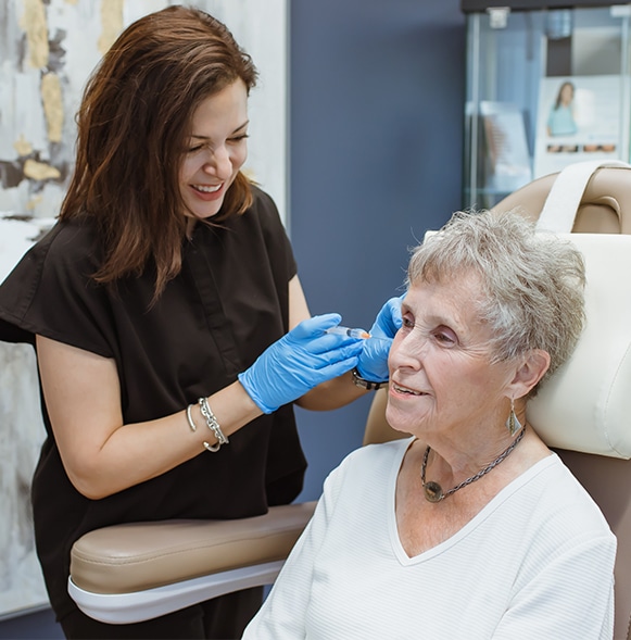 Patient and Physician laughing over conversation as doctor treats patient with sculptra