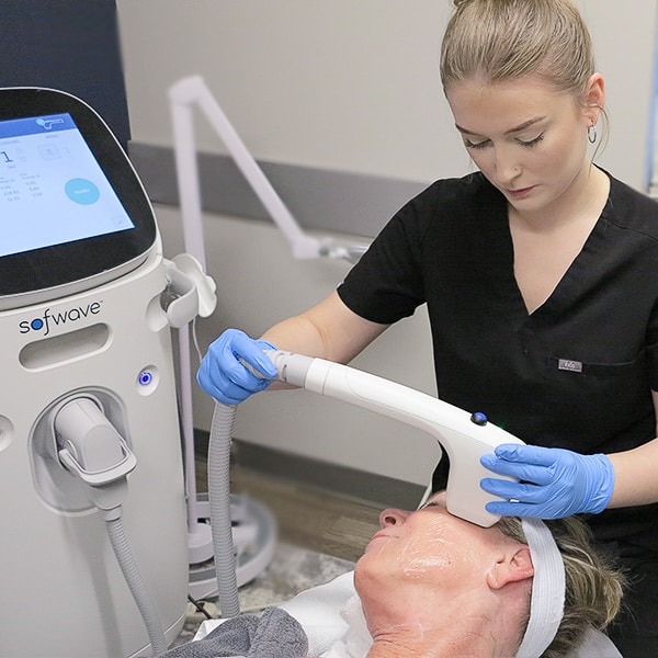 Master Esthetician lifting patient's brow with Sofwave