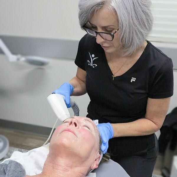 Master Esthetician tightening and lifting patient's face with Sofwave