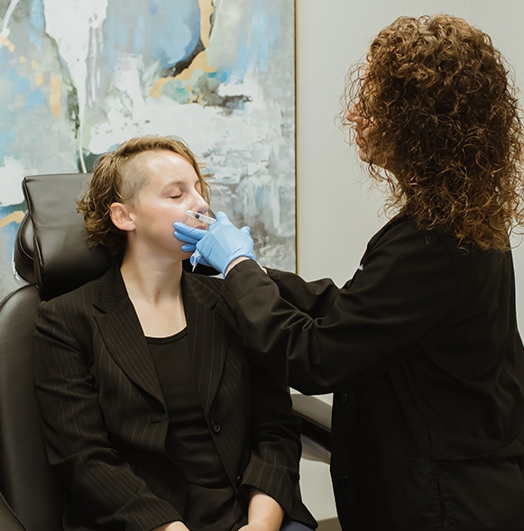 Physician is injecting PRP into the patients cheeks.